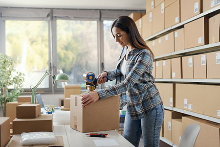 warehouse,worker,taping,a,cardboard,delivery,box,using,a,tape